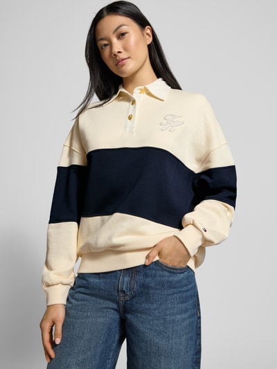 Vrouwenmodel draagt Relaxed Fit Sweatshirt uit katoenmix van Tommy Hilfiger in tweekleurige look met gestikt logo, polokraag, lange mouw, geribde rompzoom, sweatmateriaal, voorkant bovenlichaam close-up.