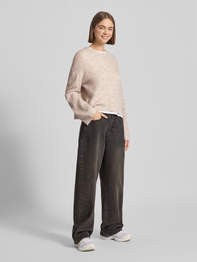 Modelka nosi Regular Fit Strickpullover mit Rundhalsausschnitt Modell 'SIMONI' von Only w melanżowej optyce, krój regular fit, długi rękaw, ściągacze na rękawach i dole, dzianina; widok całej sylwetki z przodu.