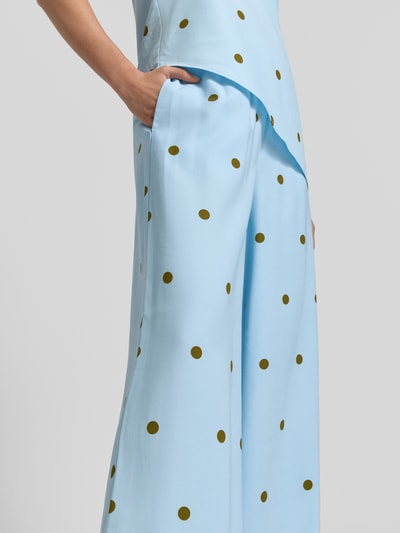 Frauenmodel trägt Fließende Hose mit weitem Bein - curated by Mary Braun von Style Icon Collection aus Viskose-Mix, hellblau mit gelben Punkten, elastischer Bund, weites Bein, glatter Stoff, Nahaufnahme Oberkörper.