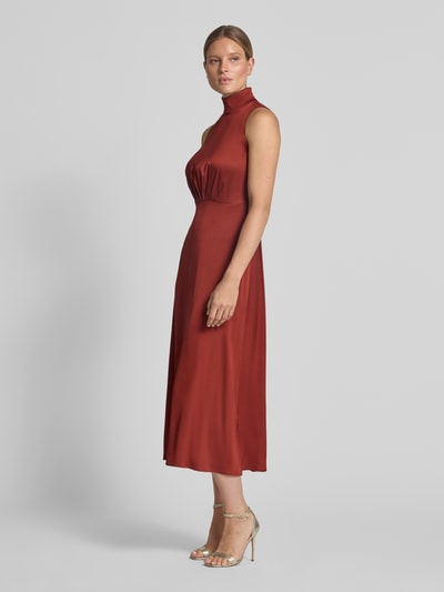 Frauenmodel trägt Maxikleid mit Stehkragen und Drapierungen Modell 'AMABEL' von DRYKORN in Rot, A-Linie, Material-Mix mit Stretch, Ganzkörperansicht von vorne.