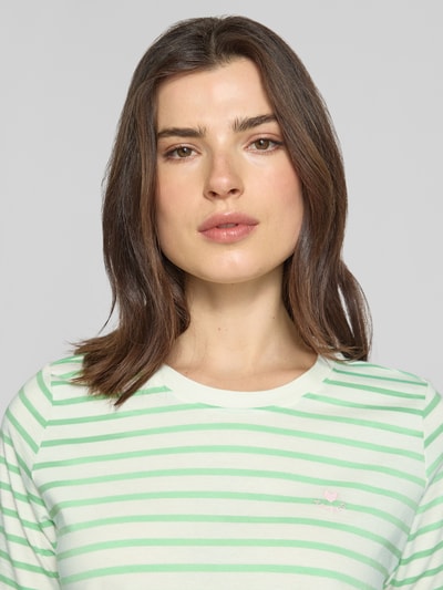 Frauenmodel trägt Regular Fit T-Shirt aus reiner Baumwolle von s.Oliver RED LABEL, Optik: Unifarben, Muster: Gestreift, Stitching-Applikation, Rundhals, Ärmelform: Kurzarm, Materialverarbeitung: Jersey, Nahaufnahme Oberkörper.