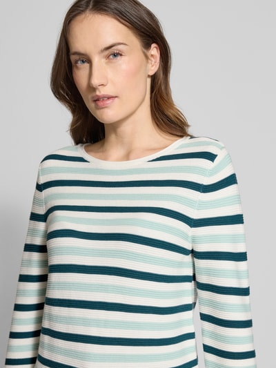 Frauenmodel trägt Regular Fit Strickpullover aus reiner Baumwolle von Tom Tailor, gestreiftes Allover-Muster, Nahaufnahme Oberkörper.