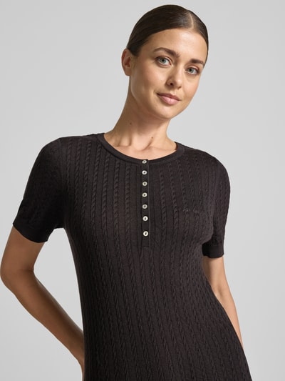 Frauenmodel trägt engen Wollpullover aus reiner Wolle Modell 'MEADIE' von Cph Muse, Zopfmuster, Strick, Knopfleiste, Nahaufnahme Oberkörper.