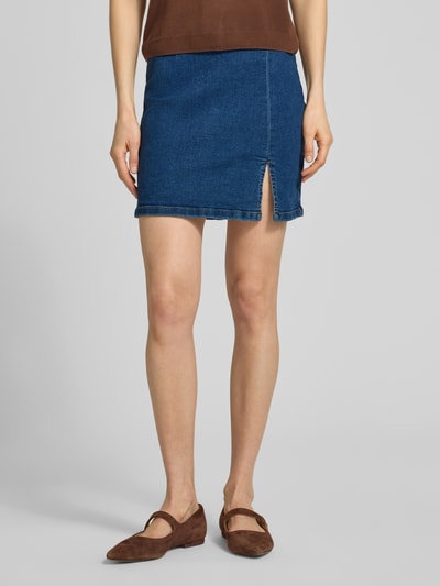 Frauenmodel trägt eng anliegenden Jeansrock aus Baumwoll-Mix Modell 'NELLY' von Vero Moda in Denim-Optik, Mini-Länge, Regular-Fit, Ganzkörperansicht von vorne.