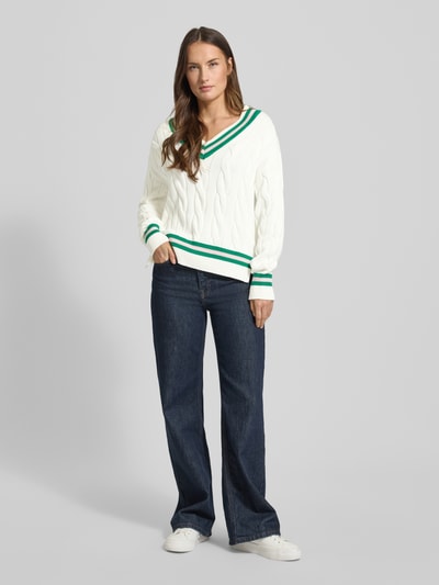 Modelka kobieca nosi Strickpullover mit V-Ausschnitt von Christian Berg Woman z białej bawełny, regular fit, zielone akcenty, całkowity widok z przodu.