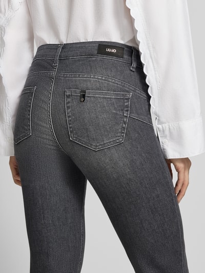 Kobiece modelka nosi Slim Fit Jeans mit Lyocell-Anteil Modell 'MONROE' od Liu Jo White, mieszanka bawełny i lyocellu, 5 kieszeni, szary kolor, delikatna faktura denim, tylna perspektywa, detal tylnej części, KI-modifiziertes Bild
