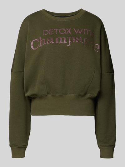 Produktfoto, Oversized Sweatshirt aus reiner Baumwolle von miss goodlife, oliwkowy kolor, okrągły dekolt, napis z różowymi zdobieniami, elastyczne wykończenia.