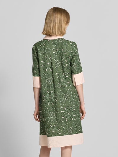 Vrouwenmodel draagt knielanges Kleid mit Polokragen und kurzer Knopfleiste van Christian Berg Woman Selection, recht model, mix van linnen en viscose, groene kleur met lichtroze accenten, textuur met fijn patroon, rugaanzicht, geheel lichaamsopname.