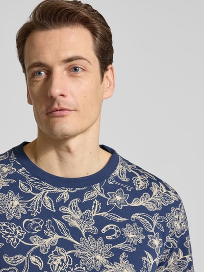 Männermodel trägt T-Shirt im Allover-Look mit Rundhalsausschnitt von Scotch & Soda in Blau, Reine Baumwolle, Regular-Fit, Nahaufnahme Oberkörper. Rückenlänge bei Größe M: 70 cm.
