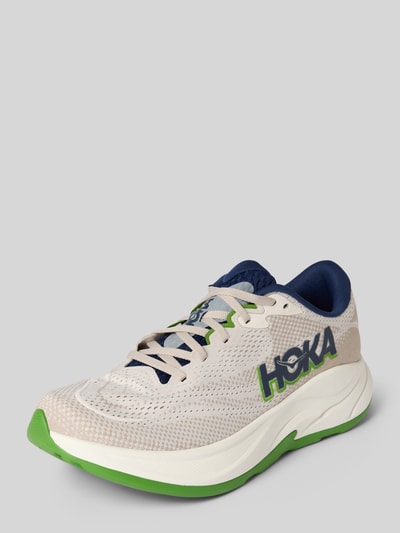 Produktfoto, Sneaker mit Logo-Detail Modell 'RINCON' von HOKA, beige Mesh-Textur, grüne und blaue Akzente, runde Form, Schnürverschluss