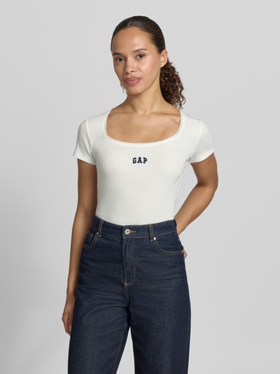 Frauenmodel trägt T-Shirt mit Logo-Stitching von GAP in Weiß, Damen T-Shirt aus Baumwoll-Mix mit Stretch-Anteil, körpernahe Passform, Rundhalsausschnitt, Rückenlänge bei Größe S 57 cm, Ganzkörperansicht von vorne.