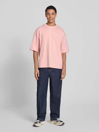 Męski model nosi Oversized T-Shirt aus reiner Baumwolle od REVIEW, bawełna, krój oversized, okrągły dekolt, nadruk z logo, długość tyłu w rozmiarze M: 66 cm, widok całej sylwetki z przodu