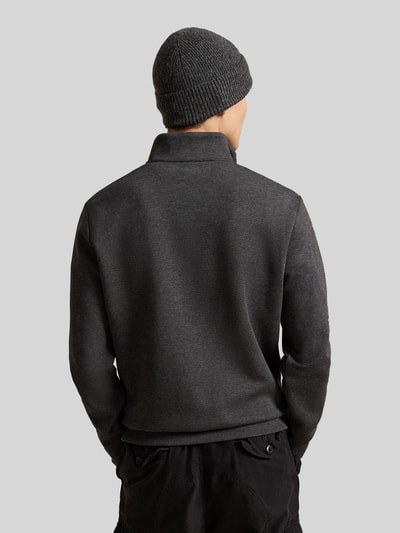 Männermodel trägt Relaxed Fit Troyer aus Baumwoll-Mix von Polo Ralph Lauren in Dunkelgrau, glatte Oberfläche, Ganzkörperansicht Rückansicht.