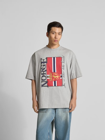 Männermodel trägt Herren T-Shirt mit Rundhalsausschnitt von VETEMENTS aus Reine Baumwolle, Lockerer-Schnitt, kurzärmelig, Unifarbenes-Design, Rückenlänge bei Größe M 79 cm, Ganzkörperansicht von vorne.