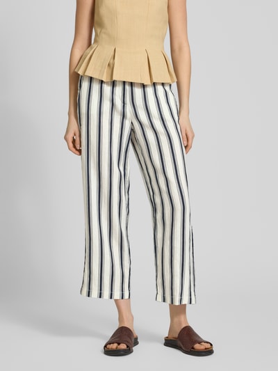 Frauenmodel trägt Straight Fit Leinenhose in verkürzter Passform von Christian Berg Woman, weiß mit dunkelblauen Streifen, reine Leinen, Nahaufnahme Unterkörper.