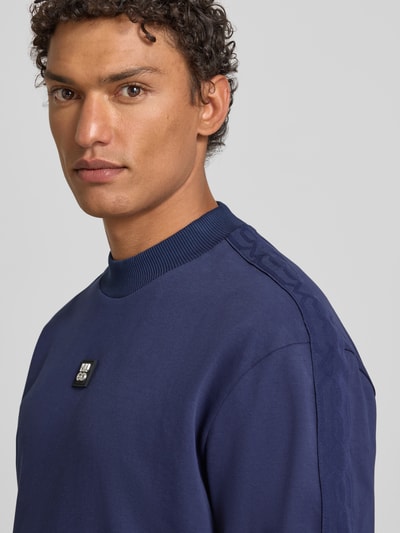 Männermodel trägt Relaxed Fit T-Shirt aus reiner Baumwolle Modell 'DANOVOTI' von HUGO, Optik: unifarben, Label Patch, Nahaufnahme Oberkörper