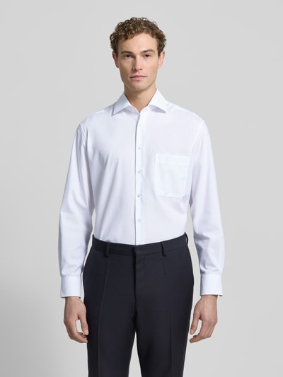 Męskimodel prezentuje Comfort Fit Businesshemd aus Popeline od ETERNA, biała bawełna, długi rękaw, kołnierzyk new kent, nie wymaga prasowania, listwa guzikowa, sportowe mankiety. Ganzkörperansicht von vorne.