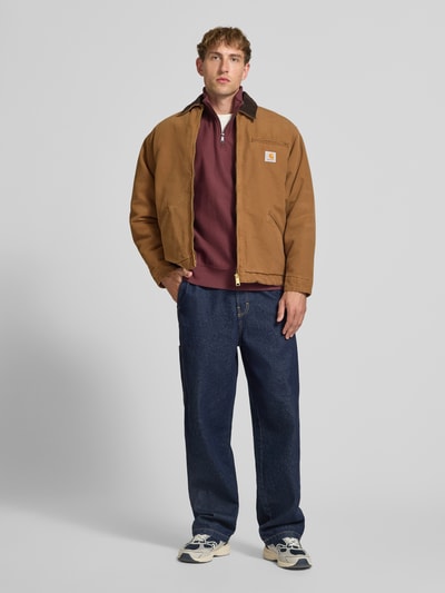 Männermodel trägt Blouson mit Brusttasche Modell 'DETROIT' von Carhartt Work In Progress in Braun, Regular Fit, Ganzkörperansicht von vorne.