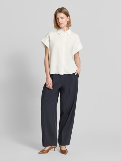 Frauenmodel trägt Boxy Fit Bluse aus Viskose-Mix Modell 'Zelya' von Someday in Creme mit Knopfleiste, Kombination mit dunkler Hose, Ganzkörperansicht von vorne. Rückenlänge bei Größe 36: 55 cm, Hemdblusenkragen.