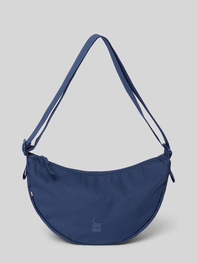 Produktfoto, Umhängetasche mit Label-Detail von Gotbag in Dunkelblau, Hauptfach mit Reißverschluss, verstellbarer Schulterriemen, Innenfach mit Reißverschluss, Maße ca. 32 cm Breite, 19 cm Länge, 10 cm Tiefe, Riemenlänge ca. 82 cm. Glatte Struktur und abgerundete Form.