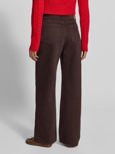 Frauenmodel trägt Relaxed Fit Jeans aus reiner Baumwolle von MYON in Dunkelbraun, 5-Pocket-Design, Rückansicht Ganzkörperansicht.