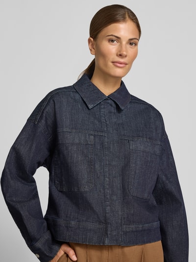 Frauenmodel trägt Regular Fit Jeansjacke aus Baumwoll-Mix Modell 'Hollins' von OPUS in dunklem Denim, Struktur der Jacke klar erkennbar, Nahaufnahme Oberkörper. Damen Jeansjacke von OPUS.