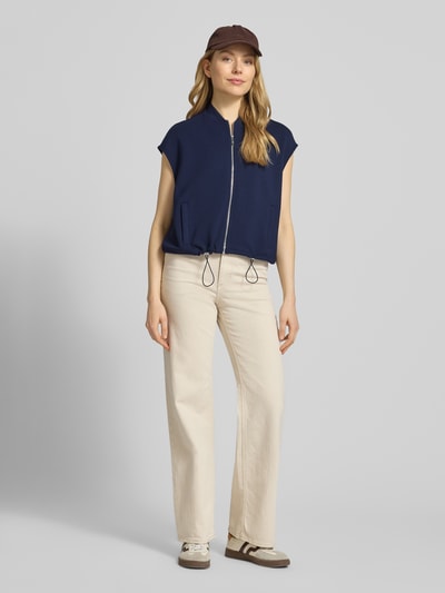 Frauenmodel trägt Regular Fit Weste mit Stehkragen von Christian Berg Woman in Dunkelblau, Elastischer-Material-Mix mit Modal-Mix, Tunnelzug, Eingrifftaschen, Reißverschluss, Ganzkörperansicht von vorne.