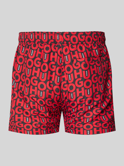 Produktfoto, Badeshorts mit Allover-Muster Modell 'NALU' von HUGO in Rot mit elastischem Bund, Tunnelzug und seitlichen Eingrifftaschen.