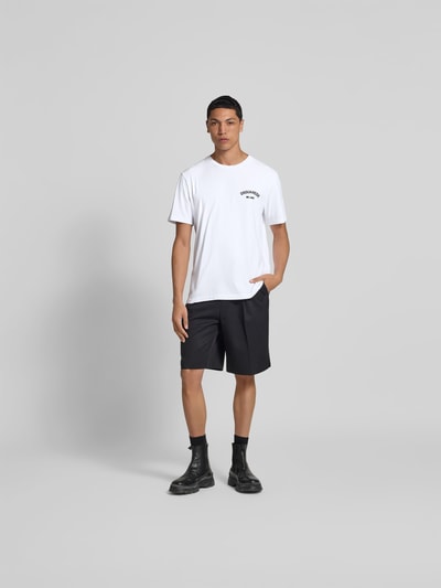 Männermodel trägt weißes Herren T-Shirt mit Label-Print von Dsquared2, Regular-Fit, reine Baumwolle, gerippter Rundhalsausschnitt, Ganzkörperansicht von vorne.