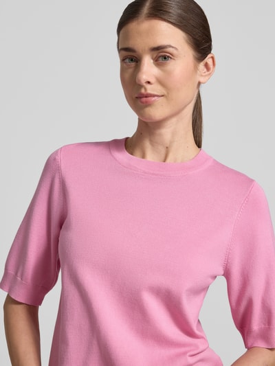 Frauenmodel trägt Strickshirt aus Viskose-Mix mit Rundhalsausschnitt Modell 'LENA' von YAS in Rosa, 1/2-Arm, Körpernaher-Schnitt, Nahaufnahme Oberkörper.