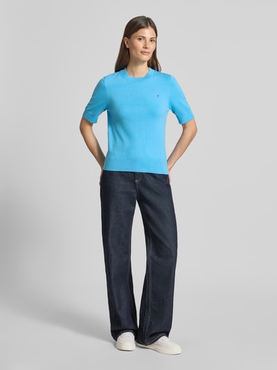 Frauenmodel trägt Regular Fit Strickpullover aus Baumwoll-Mix von Tommy Hilfiger in Optik: Unifarben, Kurzarm, Feinstrick, Logo-Stitching, Rundhals, Ganzkörperansicht von vorne.