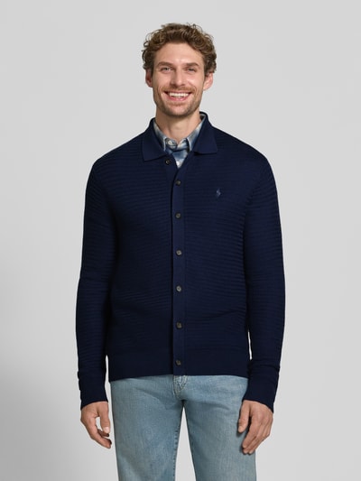 Męski model nosi Regular Fit Strickjacke aus reiner Wolle od Polo Ralph Lauren, granatowy kolor, tekstura dzianinowa, widok na cały przód.