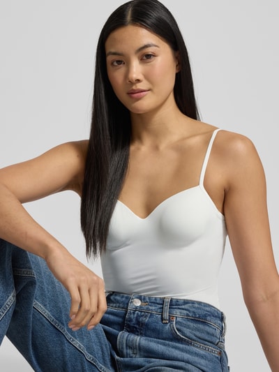 Frauenmodel trägt BH-Top mit gepolsterten, gemoldeten Cups Modell 'ALLURE' von Hanro, weißer Material-Mix mit Stretch-Anteil, körpernahe Passform, verstellbare Träger, Nahaufnahme Oberkörper.