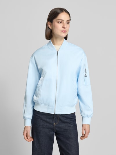 Frauenmodel trägt Regular Fit Bomberjacke mit College-Kragen von s.Oliver RED LABEL, Optik: Unifarben in Hellblau, Materialverarbeitung: Satin, seitliche Eingrifftaschen, Brustleistentasche am Ärmel, Reißverschluss, Langarm, gerippter Rumpf- und Ärmelabschluss, Ganzkörperansicht von vorne.