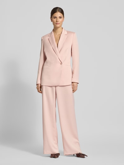 Frauenmodel trägt Relaxed Fit Blazer mit Reverskragen von Jake*s Collection in zartem Rosa, Knopfverschluss, mit Paspeltaschen, Ganzkörperansicht von vorne.