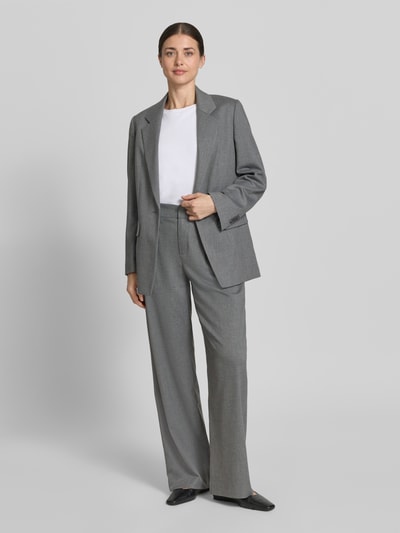 Kobiece modelka nosi Hose mit Gesäßtaschen Modell 'JEALOUS' od Drykorn, szary materiał z domieszką wiskozy, szeroka nogawka, Szerokość w rozmiarze 27/34: 37 cm, długość wewnętrzna nogawki: 81 cm, widok całej sylwetki z przodu.