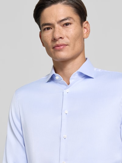 Mężczyzna nosi Slim Fit Businesshemd aus reiner Baumwolle von Jake*s, jasnoniebieski, gładka tekstura, zbliżenie na górną część ciała.