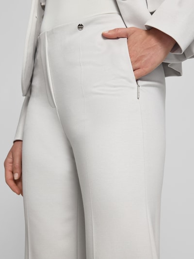 Frauenmodel trägt Hose aus Viskose-Mix mit Reißverschlusstaschen von Marc Cain in hellem Ton, Bügelfalten, Regular-Fit, Nahaufnahme Oberkörper