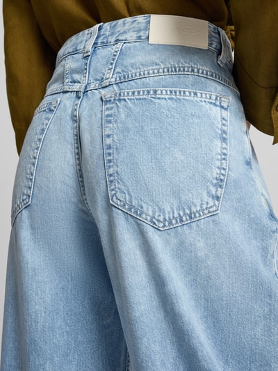 Frauenmodel trägt Barrel Fit Jeans mit Label-Detail Modell 'JAZZIE' von Closed, reine Baumwolle, hellblaue Waschung, Detailaufnahme Rückenansicht.