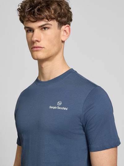 Męski model nosi Regular Fit T-Shirt mit Logo-Print von SERGIO TACCHINI, czysta bawełna, krój regular fit, dekolt okrągły, długość tyłu w rozmiarze M: 69 cm, zbliżenie na górną część ciała z przodu