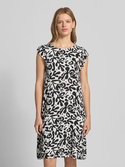 Frauenmodel trägt Regular Fit Sommerkleid aus reiner Viskose Modell 'BARRI' von Pieces, Optik: Allover-Muster, Knielang, Rundhals, Kurzarm, Schmetterlingsärmel, Materialverarbeitung: Crêpe, Farbkontrast Schwarz-Weiß, Ganzkörperansicht von vorne.