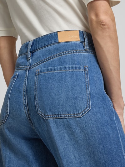 Frauenmodel trägt Regular Fit Wide Leg Jeans aus Lyocell-Baumwoll-Mix von s.Oliver BLACK LABEL in blauem Denim mit Label Patch, Nahaufnahme Rückansicht.