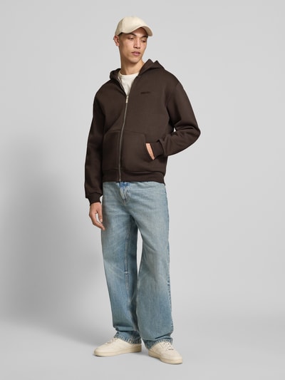 Männermodel trägt Sweatjacke mit Känguru-Tasche von REVIEW aus Baumwoll-Mix, Relaxed-Fit, Reißverschluss, Ganzkörperansicht von vorne.