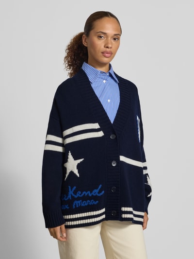 Frauenmodel trägt Oversized Strickjacke aus reiner Wolle Modell 'BELGIO' von Max Mara, dunkelblau mit weißen Details, Damen Strickjacke von Weekend Max Mara, Nahaufnahme Oberkörper.