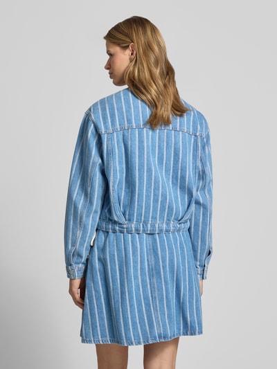 Frauenmodel trägt Relaxed Fit Jeansjacke aus reiner Baumwolle - Special Drop von Marc O'Polo Denim mit blau-weißen Streifen, Bindeschleifen, Brusttaschen, Knopfleiste, cropped Länge, Denim-Optik, Ganzkörperansicht Rückansicht.