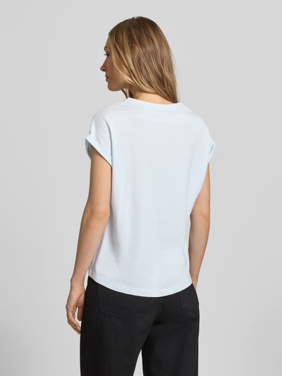 Modelka nosi Relaxed Fit T-Shirt aus reiner Baumwolle od s.Oliver RED LABEL, efekt: jednolity kolor, krój relaxed fit, aplikacja: nadruk z przodu, nadruk z logo, oversize ramiona, okrągły dekolt, rękaw: krótki rękaw z brzegiem, materiał: bawełna, widok całej sylwetki z tyłu.