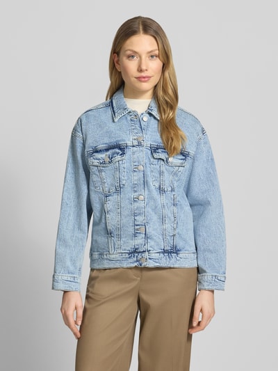 Kobiece modelka nosi Regular Fit Jeansjacke aus Baumwoll-Mix Modell 'TESSA' von Vero Moda, jasny denim, krój regular fit, wykładany kołnierz, listwa guzikowa, kieszenie na piersi i boczne, wyhaftowane logo, długie rękawy z mankietami, mieszanka bawełny, efekt: jednolity kolor, karczek z tyłu, tekstura: gładka. Ganzkörperansicht von vorne.