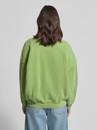 Vrouwenmodel draagt Sweatshirt met Label-Print model 'PLIZZY' van American Vintage in groen, relaxed fit, puur katoen, totaal achteraanzicht.