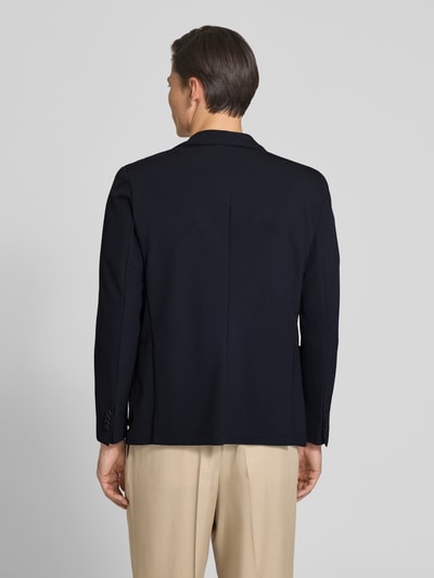 Männermodel trägt Slim Fit 2-Knopf-Blazer mit Reverskragen von MARKUP, dunkle Farbe, Material-Mix mit Stretch-Anteil, Ganzkörperansicht Rückansicht. Rückenlänge 70 cm, Schulterbreite 40 cm, Ärmellänge 65 cm, aufgesetzte Taschen, glatte Oberfläche.