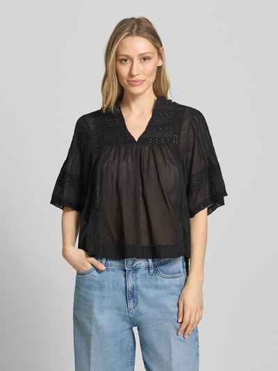 Frauenmodel trägt Blusenshirt mit V-Ausschnitt Modell 'Siama' von Neo Noir in Schwarz mit Stitchings, Regular-Fit, Ganzkörperansicht von vorne. Rückenlänge bei Größe 36: 56 cm, Ärmellänge bei Größe 36: 28 cm.